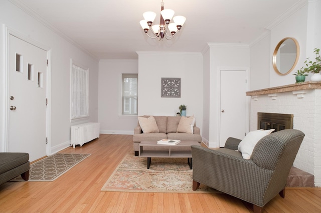 living room with a chandelier, ornamental molding, radiator heating unit, a fireplace, and hardwood / wood-style floors