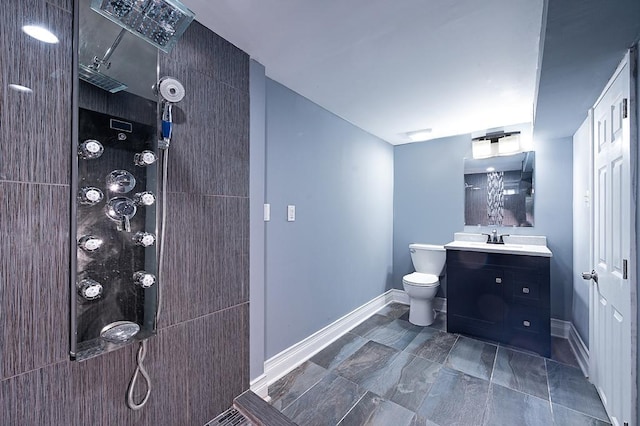 bathroom featuring vanity, toilet, and tiled shower