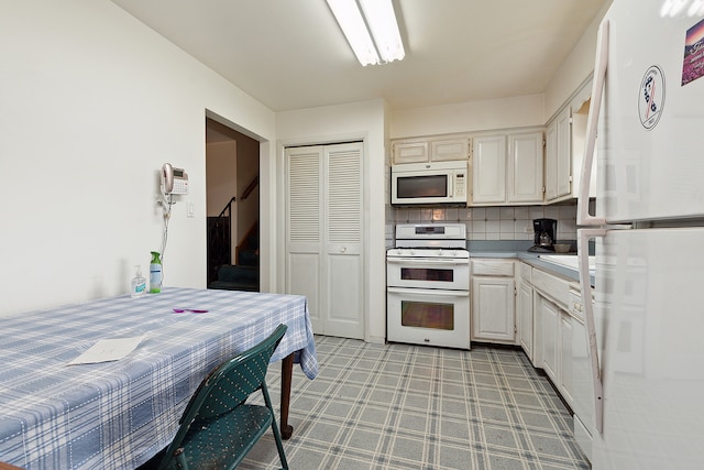 kitchen with white cabinets, tasteful backsplash, and white appliances