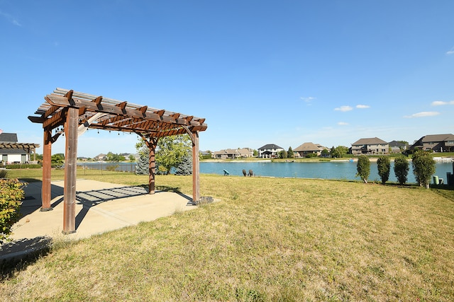 view of community featuring a yard, a pergola, a water view, and a patio area