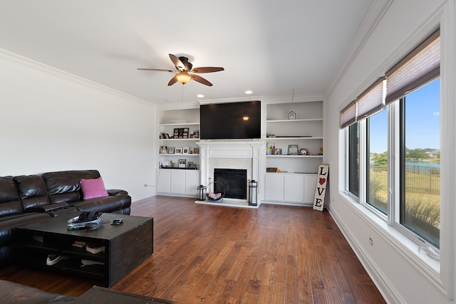 living room featuring ornamental molding, ceiling fan, dark hardwood / wood-style floors, and built in shelves