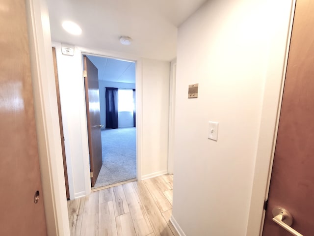 corridor with light hardwood / wood-style floors