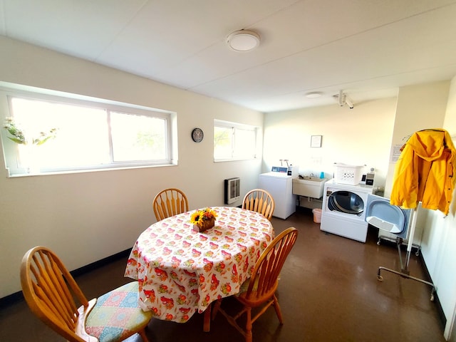 dining area featuring heating unit, sink, and washing machine and clothes dryer