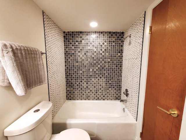 bathroom with tiled shower / bath combo and toilet