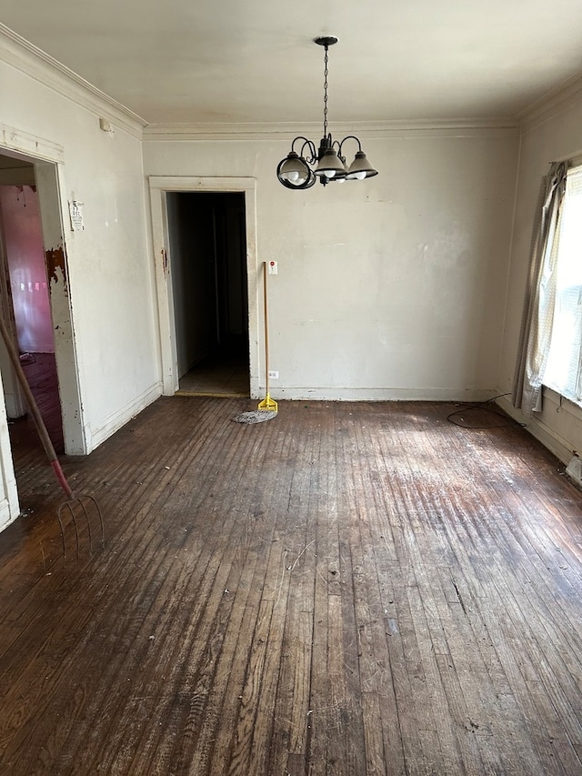 unfurnished dining area with dark wood-type flooring, an inviting chandelier, and crown molding