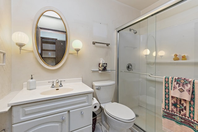 bathroom with vanity, toilet, and a shower with shower door