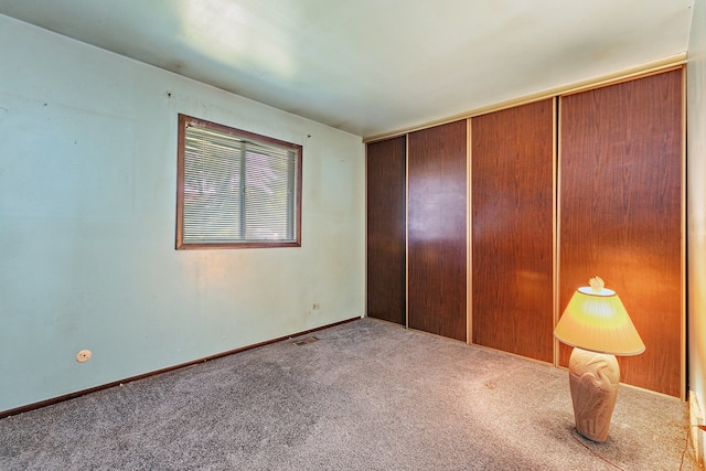 unfurnished bedroom with a closet and carpet flooring