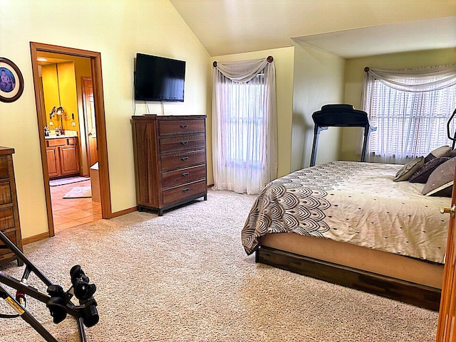 carpeted bedroom featuring connected bathroom and vaulted ceiling