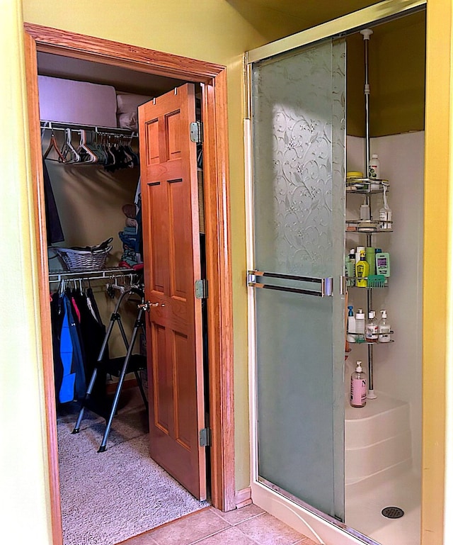 bathroom featuring a shower with door and tile patterned flooring