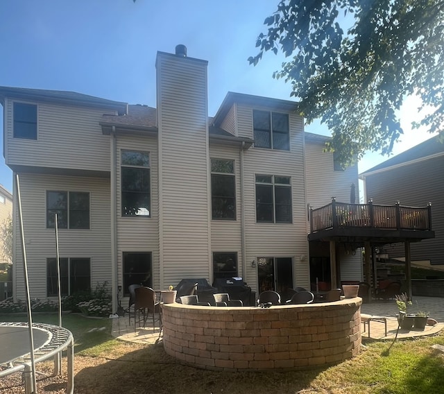 back of property featuring a trampoline and a patio area