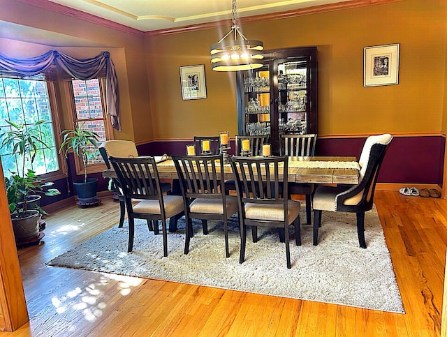 dining space featuring hardwood / wood-style floors, a chandelier, and crown molding