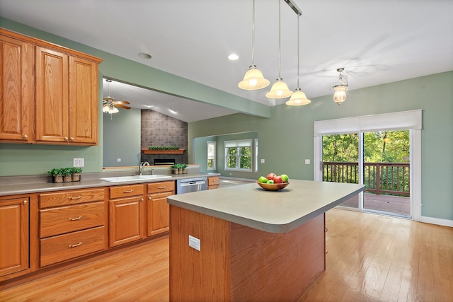 kitchen featuring sink, decorative light fixtures, dishwasher, a kitchen breakfast bar, and light wood-type flooring