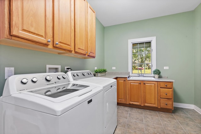 laundry area with cabinets, independent washer and dryer, light tile patterned floors, and sink