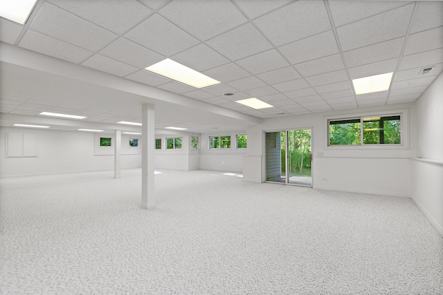 basement with a healthy amount of sunlight, carpet flooring, and a drop ceiling