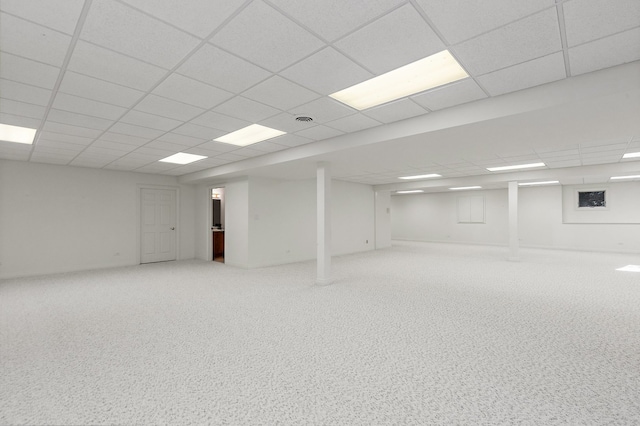 basement with a paneled ceiling and carpet flooring