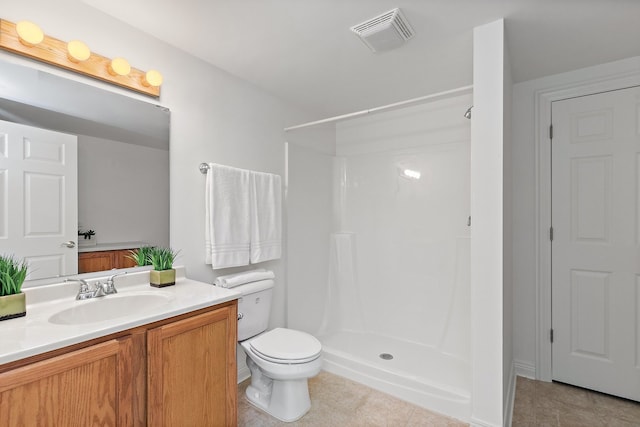 bathroom with tile patterned flooring, walk in shower, vanity, and toilet