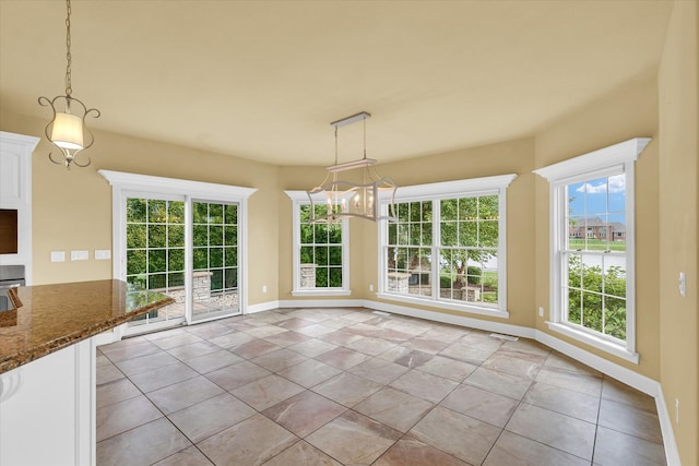 unfurnished dining area featuring an inviting chandelier and light tile patterned flooring