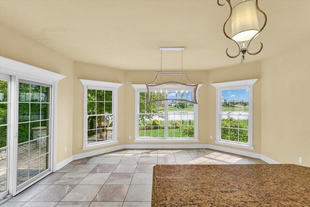 unfurnished dining area featuring tile patterned flooring and baseboards