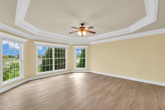 unfurnished room with light wood finished floors, ceiling fan, baseboards, and a tray ceiling