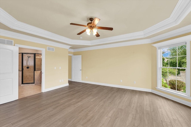 spare room featuring visible vents, ornamental molding, a ceiling fan, and wood finished floors