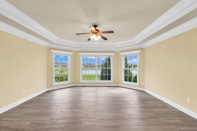 unfurnished room with a wealth of natural light, a ceiling fan, ornamental molding, and dark wood-style flooring