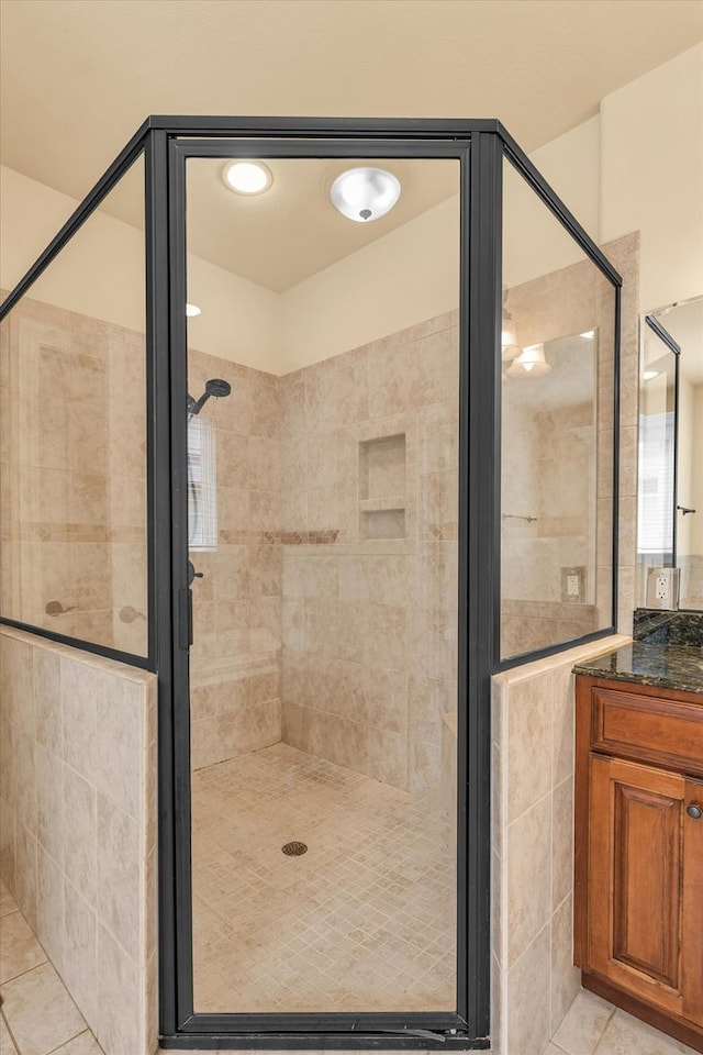 bathroom featuring vanity, a shower with shower door, and tile patterned flooring