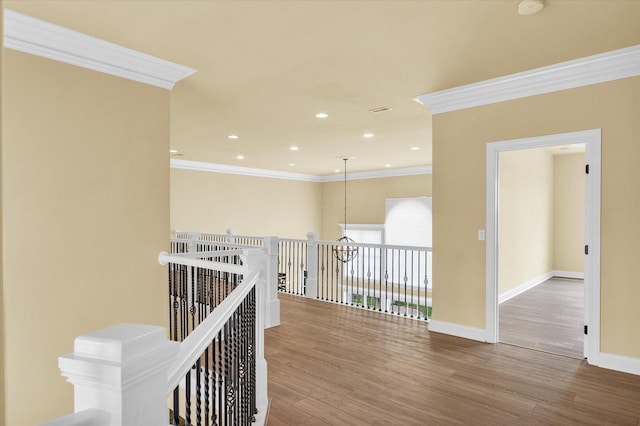 hallway featuring an upstairs landing, wood finished floors, ornamental molding, and baseboards