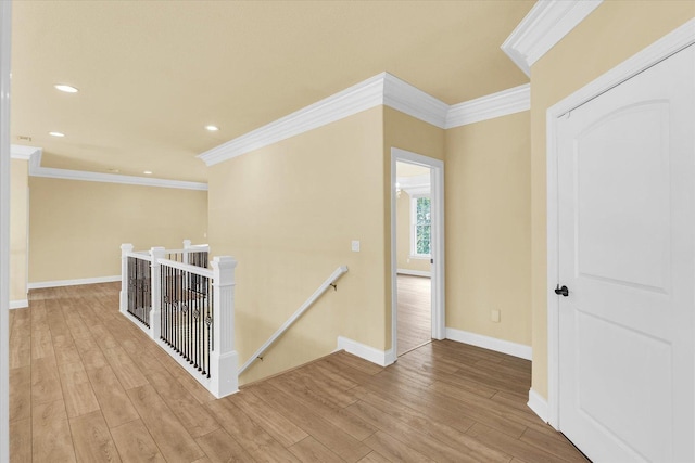 hall featuring an upstairs landing, baseboards, recessed lighting, ornamental molding, and wood finished floors