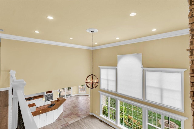 hallway featuring crown molding, recessed lighting, an inviting chandelier, and baseboards