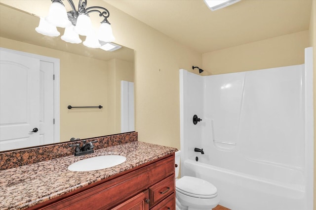 bathroom with toilet, a notable chandelier, shower / bathing tub combination, and vanity