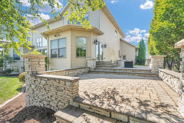 rear view of property with cooling unit and a patio area