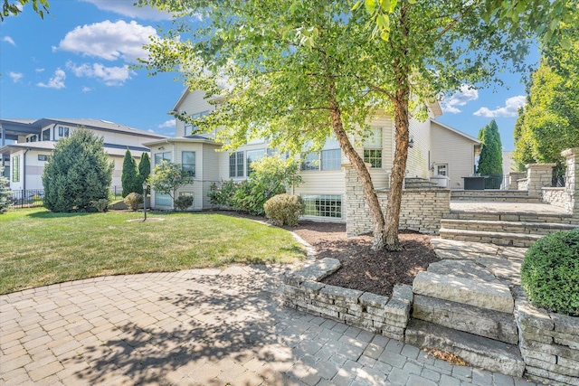 view of front of house with fence, a front yard, and a patio