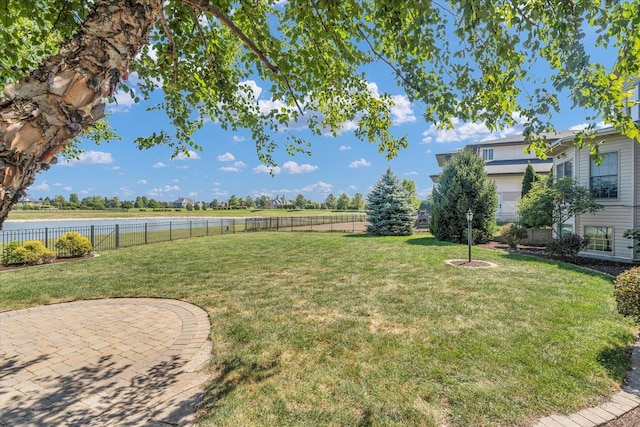 view of yard with a water view and a fenced backyard