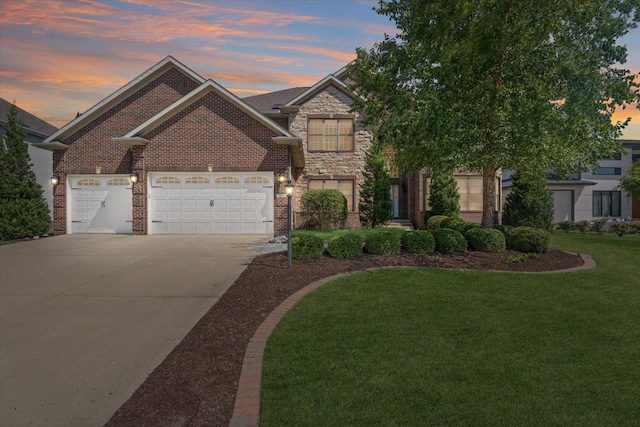 view of front of house with a garage, a lawn, driveway, stone siding, and brick siding