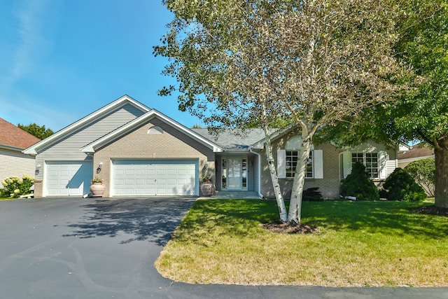 ranch-style house featuring a front yard and a garage