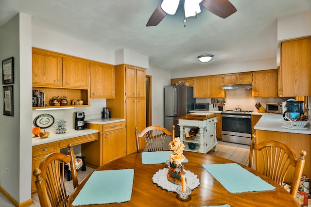 kitchen featuring ceiling fan, light tile patterned floors, and stainless steel appliances