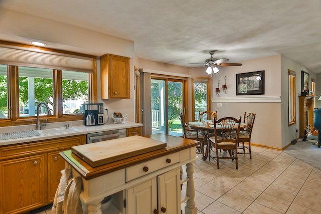 kitchen with dishwasher, ceiling fan, sink, and light tile patterned floors