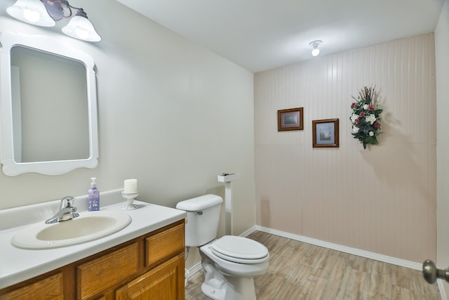 bathroom with toilet, hardwood / wood-style flooring, and vanity