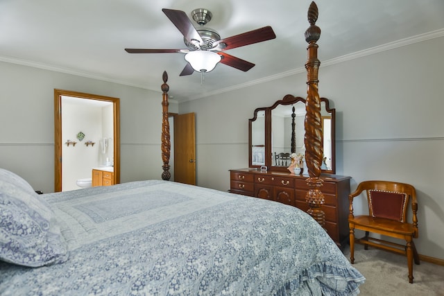 carpeted bedroom with ensuite bath, ornamental molding, and ceiling fan