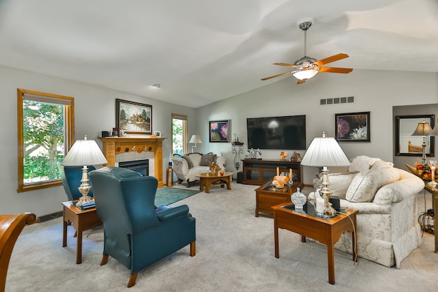 carpeted living room featuring ceiling fan, a tiled fireplace, and vaulted ceiling