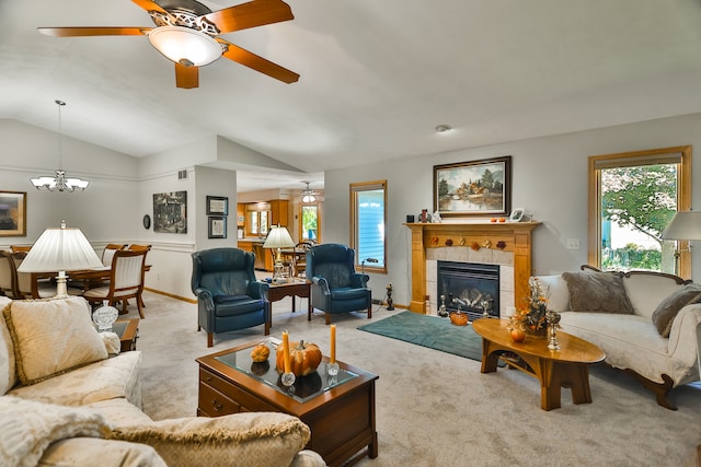 carpeted living room featuring vaulted ceiling, a tiled fireplace, and ceiling fan with notable chandelier