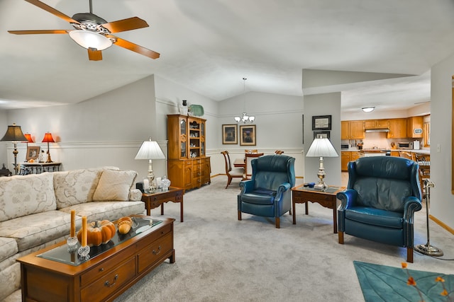 living room with ceiling fan with notable chandelier, vaulted ceiling, and light colored carpet