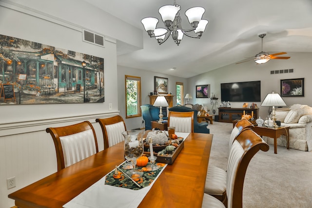 dining area featuring wood walls, ceiling fan with notable chandelier, a fireplace, lofted ceiling, and carpet flooring