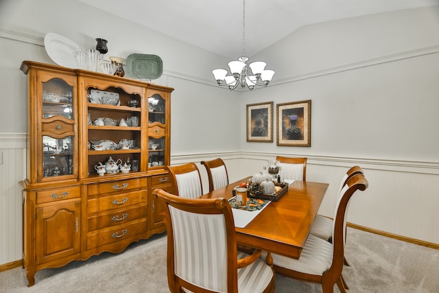 dining space with lofted ceiling, light carpet, and a notable chandelier