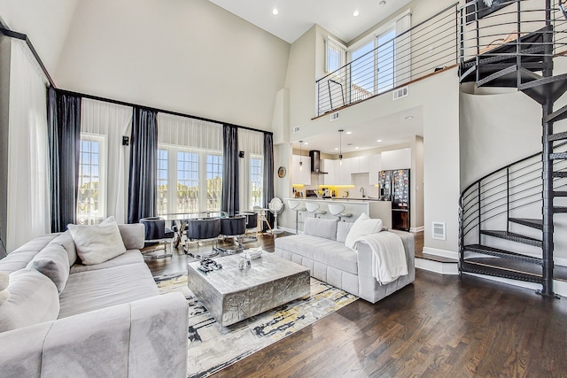 living room with a towering ceiling and dark hardwood / wood-style floors