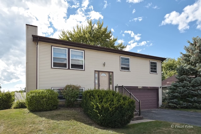 bi-level home featuring a front yard and a garage