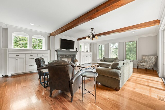 living room with ornamental molding, plenty of natural light, a chandelier, and light hardwood / wood-style floors