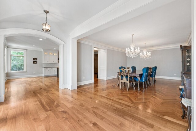 dining space with crown molding, an inviting chandelier, and parquet floors