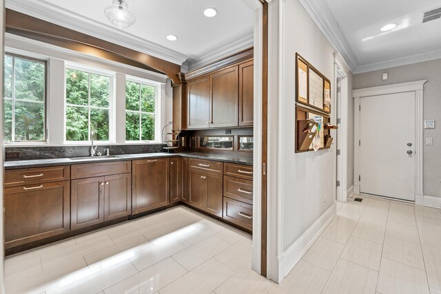 kitchen with ornamental molding, sink, light tile patterned flooring, and dishwasher