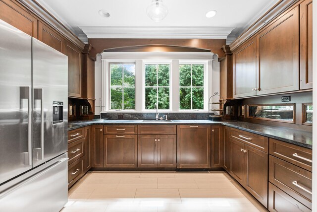 kitchen featuring light tile patterned floors, stainless steel fridge with ice dispenser, crown molding, sink, and dark stone countertops